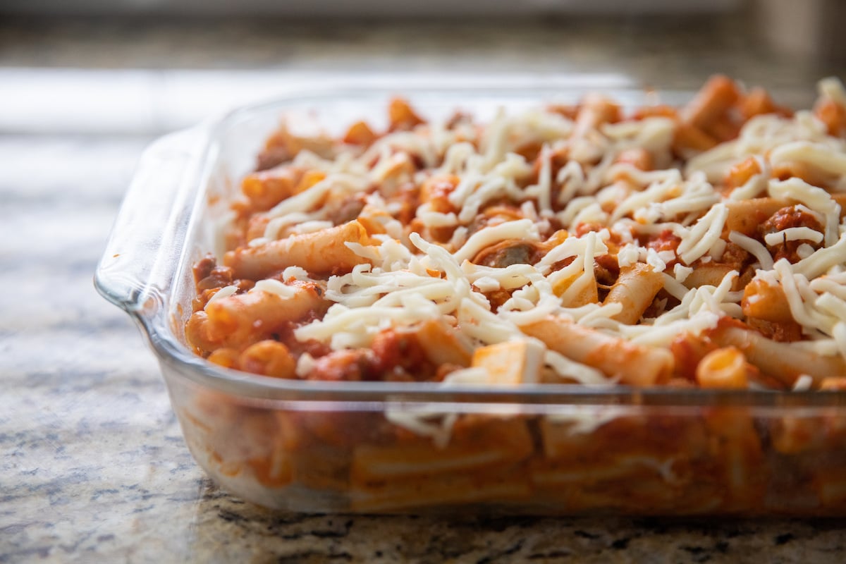baked ziti topped with cheese in baking dish before baking