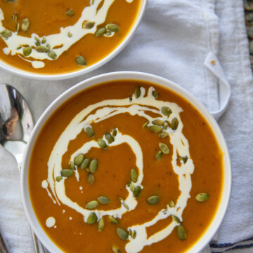 top down view of pumpkin soup in two bowls